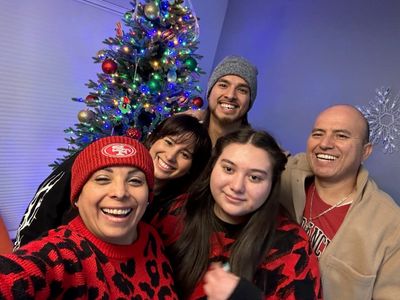 Family photo of the declare it restored & remodeled team in front of a Christmas tree