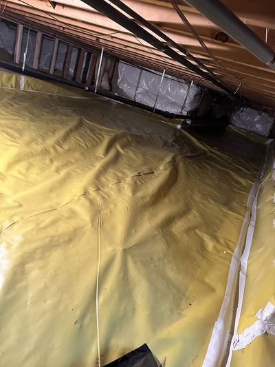 Crawl space set up with yellow and white moisture barriers