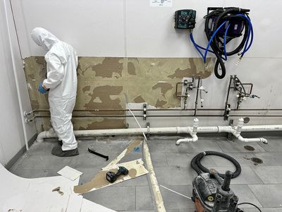 declare it restored & remodeled technician working on commercial building wall facet