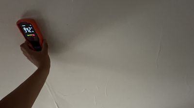 Technician using an infrared moisture detection device