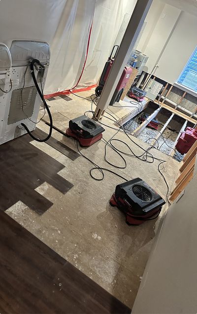 Commercial dehumidification equipment set up on the floor of a residential home that has experience flooding